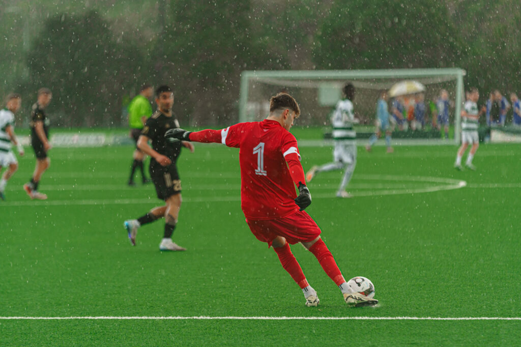 Auckland United FC goalkeeper strikes the ball down field.